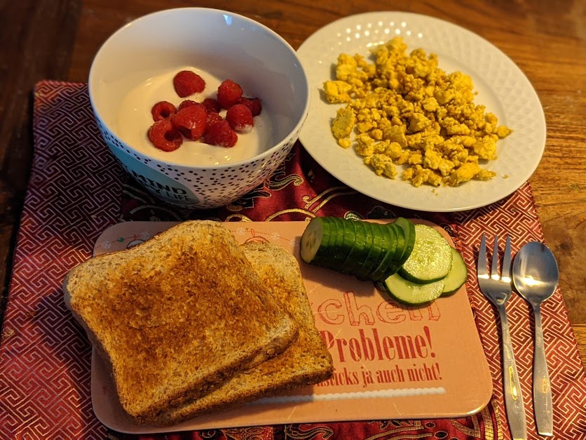 Veganer Naturjoghurt mit beeren, veganes Rührei, Toast und Gurke